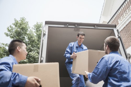 Movers handling furniture in a narrow central London property