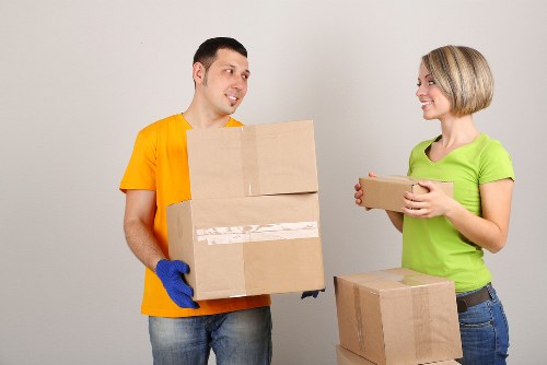 Professional movers carrying household items through a narrow stairwell in Fitzrovia